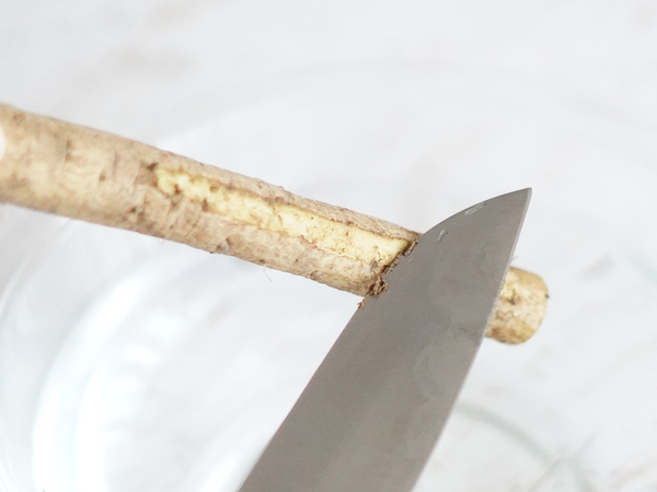 ごぼうの皮を包丁の背でこそぎ落とす